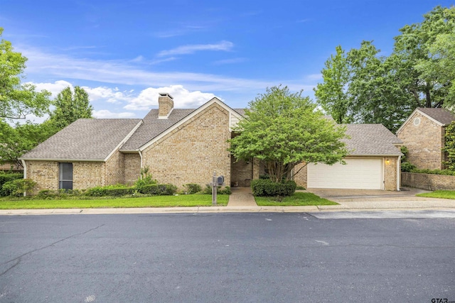 view of front of property featuring brick siding, a shingled roof, a chimney, a garage, and concrete driveway