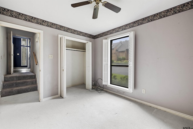 unfurnished bedroom with carpet floors, baseboards, a closet, and a ceiling fan