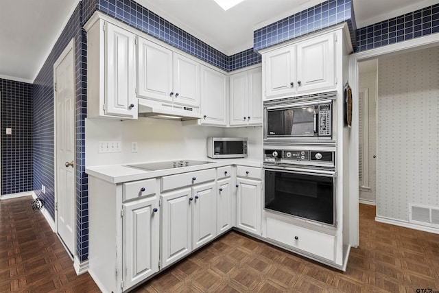 kitchen featuring oven, black electric cooktop, built in microwave, stainless steel microwave, and under cabinet range hood