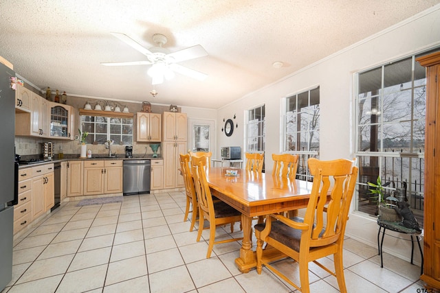 tiled dining area with sink, crown molding, and a textured ceiling