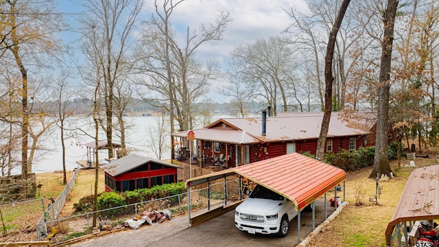 exterior space featuring a sunroom, a water view, and a carport