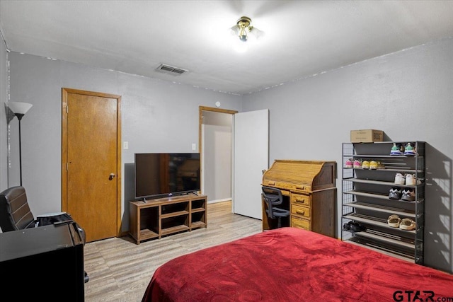 bedroom with light wood-type flooring and visible vents