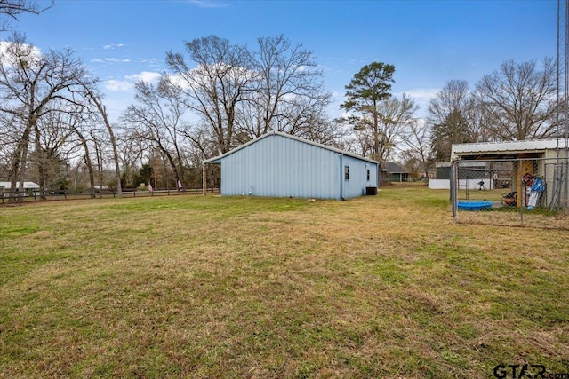 view of yard with a pole building, an outdoor structure, and fence