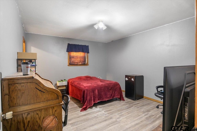 bedroom with baseboards and light wood finished floors