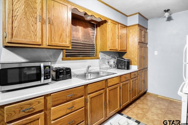 kitchen with stainless steel microwave, brown cabinets, light countertops, light floors, and a sink