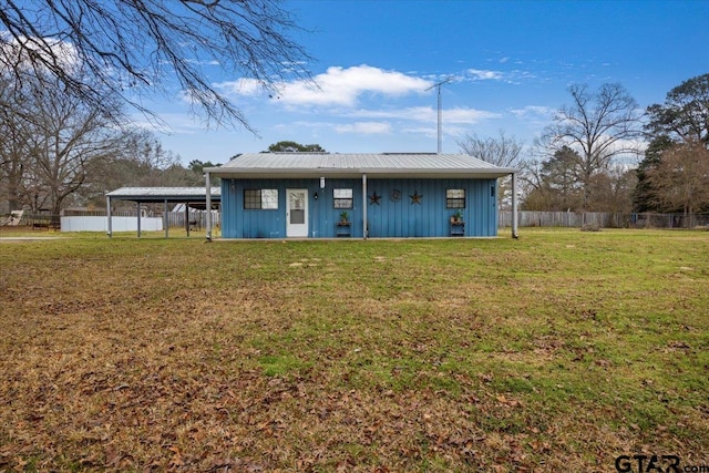 view of front of home with metal roof, fence, a front lawn, and board and batten siding