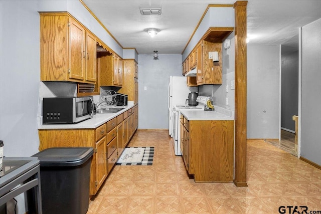 kitchen featuring brown cabinets, white electric range oven, light countertops, stainless steel microwave, and visible vents