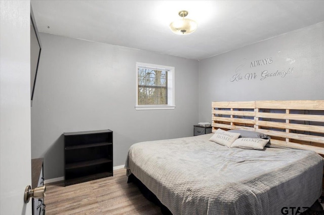 bedroom featuring light wood-style floors and baseboards