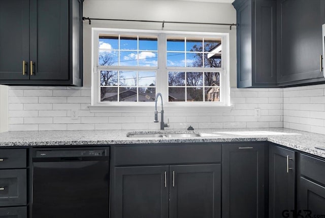 kitchen featuring black dishwasher, a sink, light stone countertops, and decorative backsplash