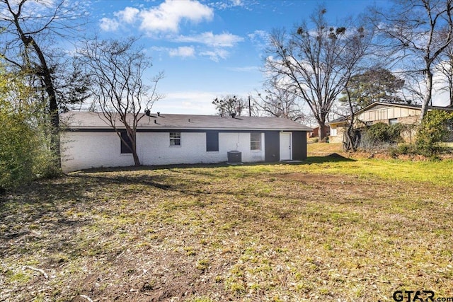 back of property featuring a lawn and central AC