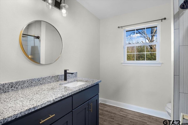 full bathroom with toilet, wood finished floors, vanity, and baseboards