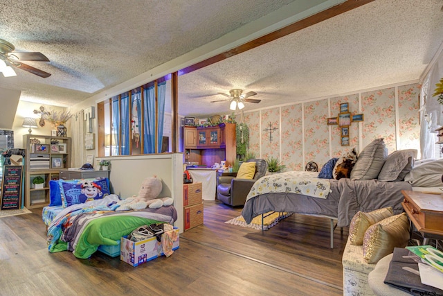 bedroom with ceiling fan, wood-type flooring, and a textured ceiling