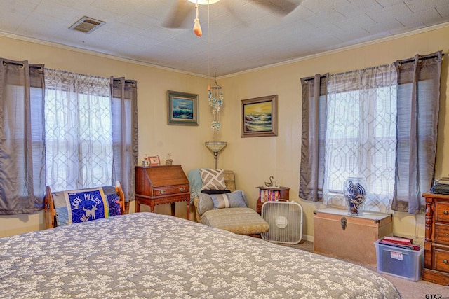 carpeted bedroom with ceiling fan and ornamental molding