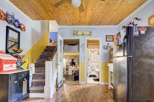 stairs featuring wood walls, crown molding, wood-type flooring, and wooden ceiling