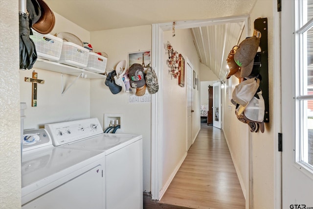 laundry area featuring laundry area, washing machine and dryer, light wood-style flooring, and baseboards