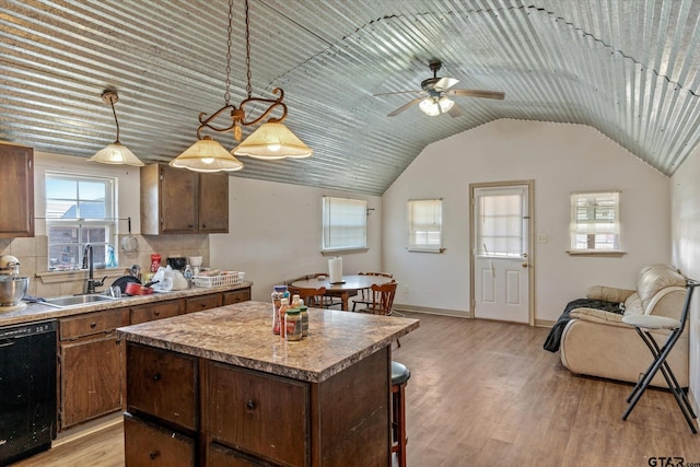 kitchen featuring a kitchen island, light wood-style flooring, ceiling fan, a sink, and dishwasher