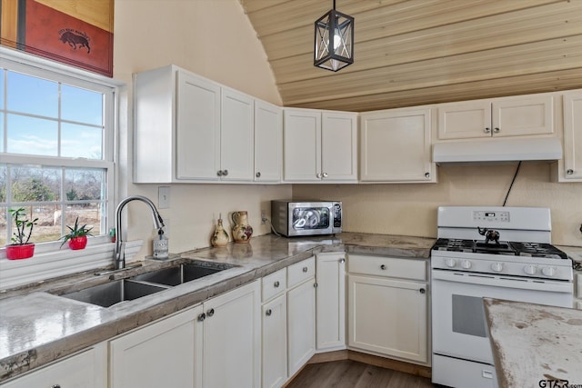 kitchen featuring white gas stove, white cabinetry, under cabinet range hood, and a sink