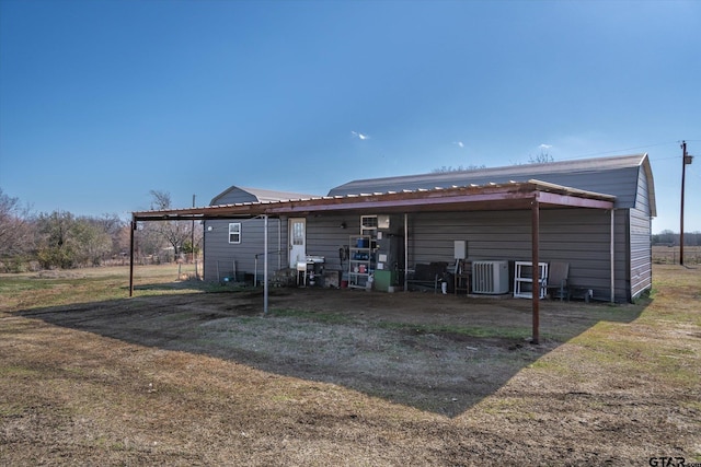 rear view of property with a carport and cooling unit