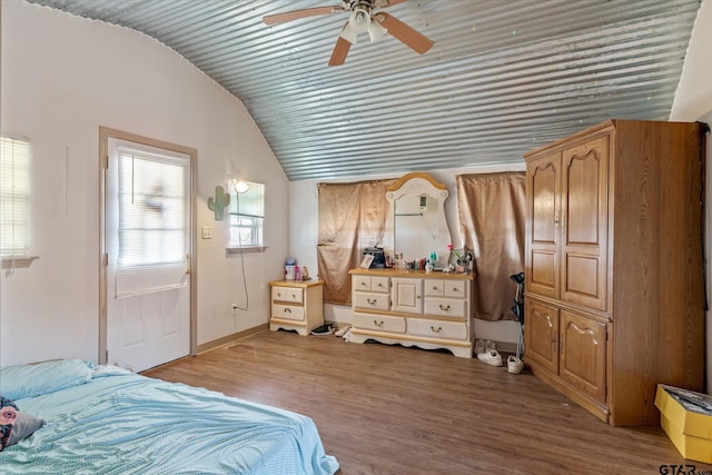 bedroom with baseboards, lofted ceiling, wood finished floors, and a ceiling fan