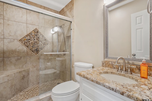 full bath with vanity, toilet, and a shower stall