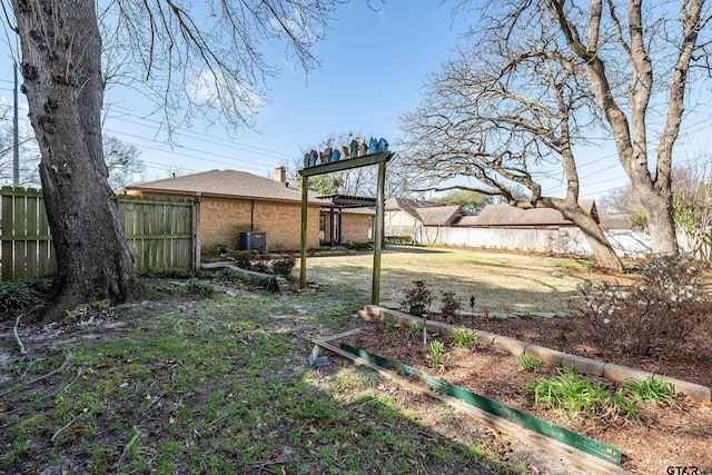 view of yard with central AC unit and fence