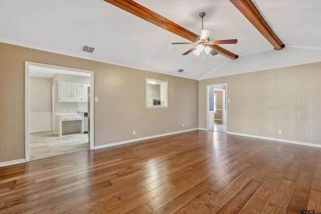 spare room with hardwood / wood-style flooring, vaulted ceiling with beams, a ceiling fan, and visible vents