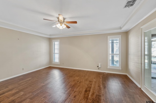 spare room with dark wood-style floors, visible vents, plenty of natural light, and a ceiling fan