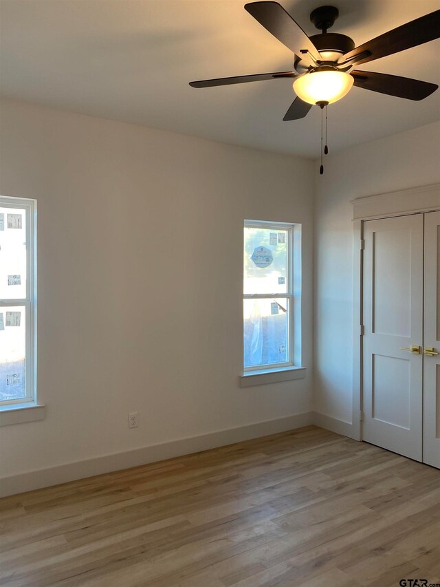 spare room featuring light wood-type flooring and ceiling fan