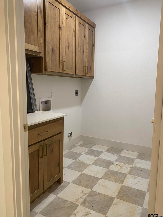 clothes washing area with electric dryer hookup, cabinets, and washer hookup