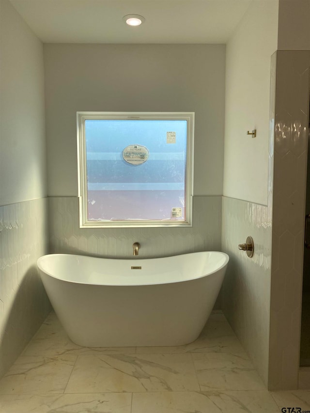 bathroom featuring a bathtub and tile walls