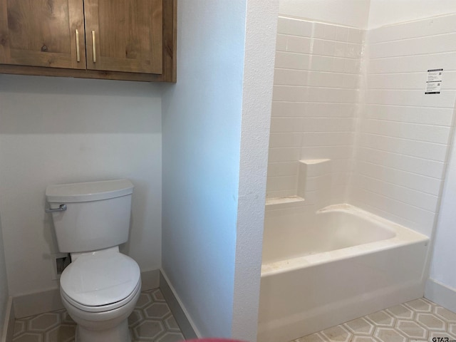 bathroom with a tub to relax in, tile patterned floors, and toilet