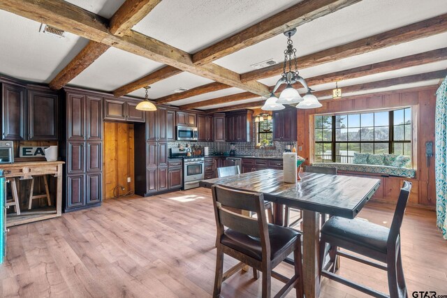 2711 N Fm 250, Hughes Springs, TX 75656 - dining area with beamed ceiling, light wood-type flooring, a chandelier, and wooden walls