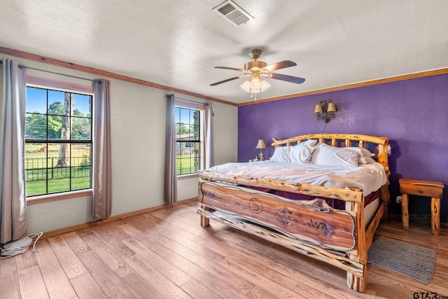 2711 N Fm 250, Hughes Springs, TX 75656 - bedroom featuring wood finished floors, crown molding, ceiling fan, and a textured ceiling