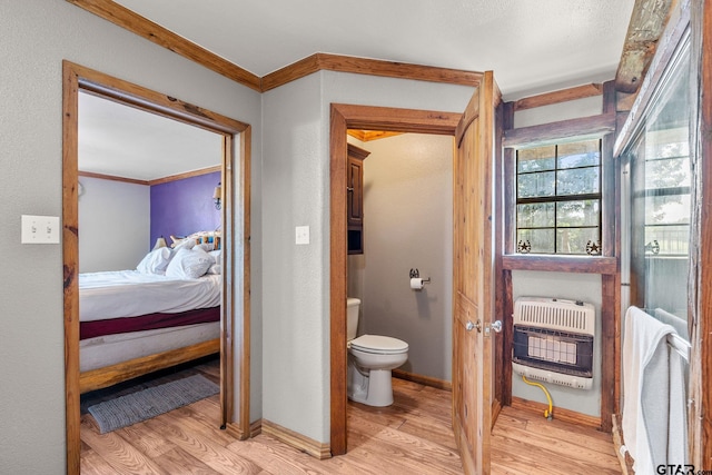 2711 N Fm 250, Hughes Springs, TX 75656 - ensuite bathroom with heating unit, wood finished floors, and crown molding