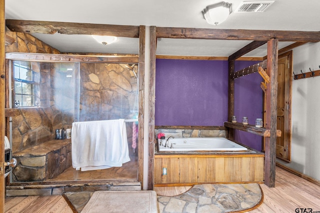 2711 N Fm 250, Hughes Springs, TX 75656 - bathroom featuring a bath, wood finished floors, beamed ceiling, and a shower stall