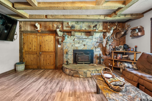 2711 N Fm 250, Hughes Springs, TX 75656 - living room with wood finished floors, beamed ceiling, and a wood stove