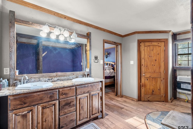 2711 N Fm 250, Hughes Springs, TX 75656 - bathroom with wood finished floors, double vanity, heating unit, ensuite bath, and ornamental molding