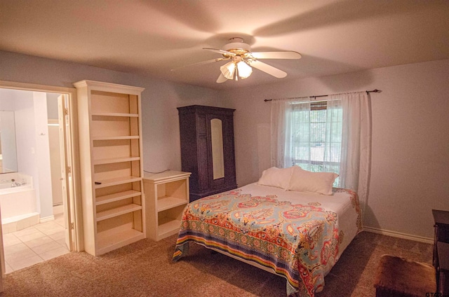 carpeted bedroom with ensuite bathroom and ceiling fan