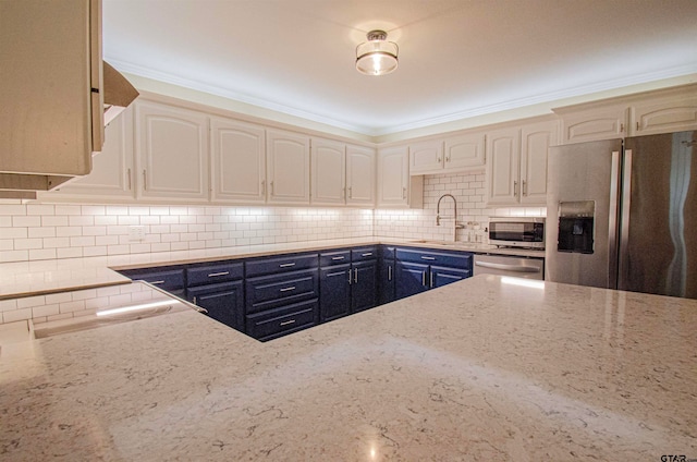 kitchen featuring light stone counters, appliances with stainless steel finishes, and tasteful backsplash