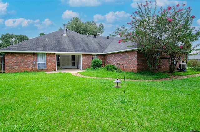 rear view of property with a patio and a yard