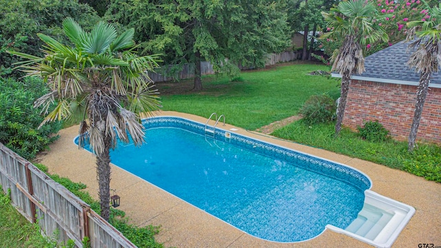 view of swimming pool featuring a lawn