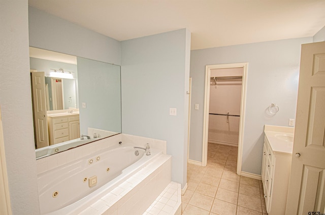 bathroom featuring tile patterned flooring, vanity, and tiled tub