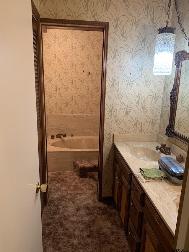 full bath featuring wallpapered walls, a bath, and vanity
