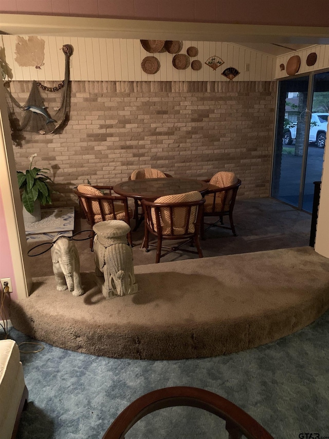 interior space with carpet and brick wall