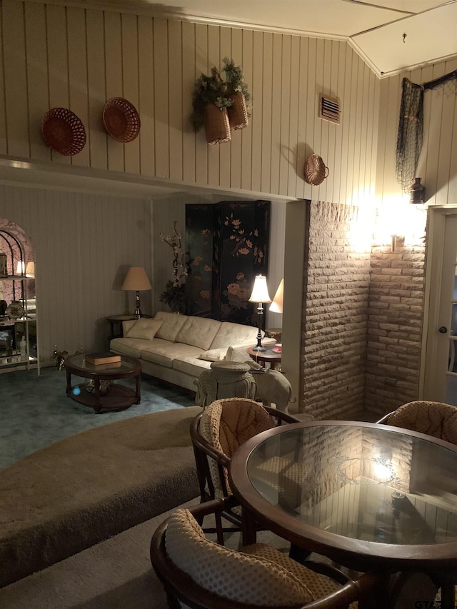 interior space with vaulted ceiling, brick wall, and visible vents