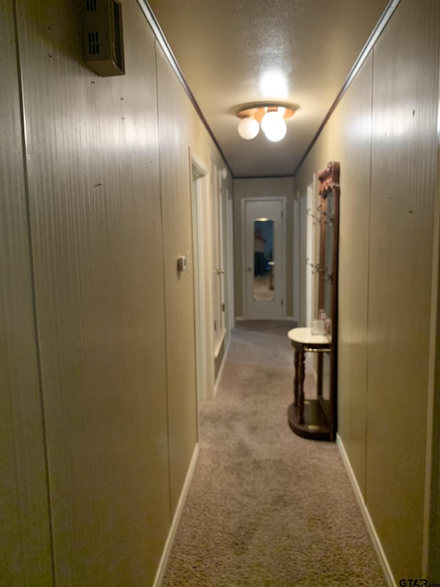 hallway featuring baseboards and light colored carpet