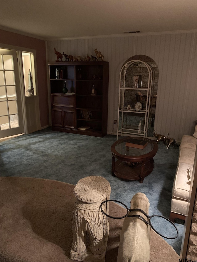 carpeted living area featuring wood walls and visible vents