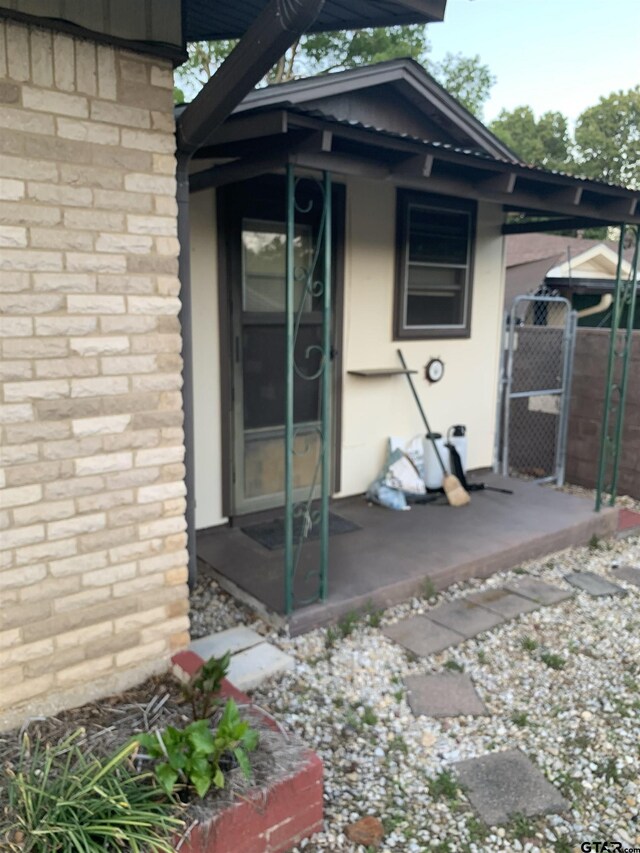 rear view of house featuring stucco siding and fence
