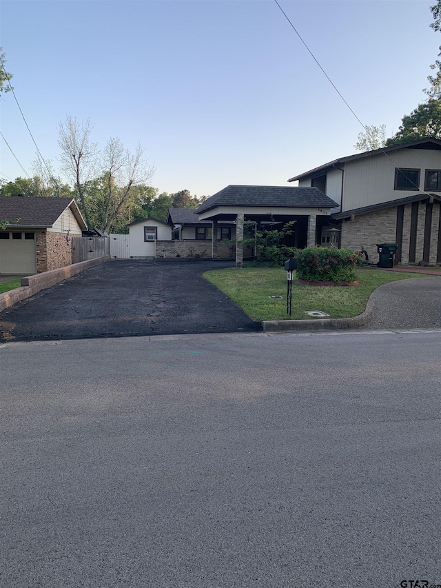 view of front of home with fence, driveway, and a front yard