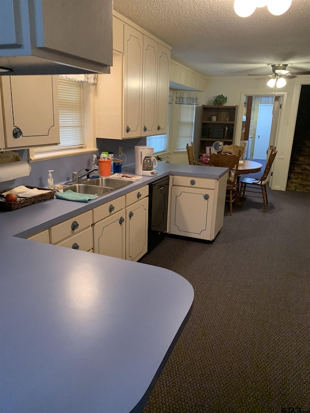 kitchen with a ceiling fan, dishwasher, a peninsula, dark carpet, and white cabinetry